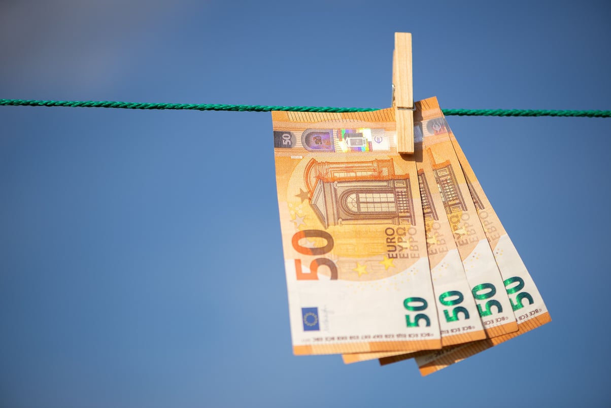 Close-up of 50 euro banknotes suspended from a clothesline.